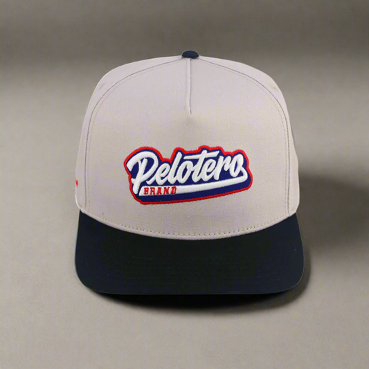Beige and black cap with 'Pelotero Brand' logo on a white background