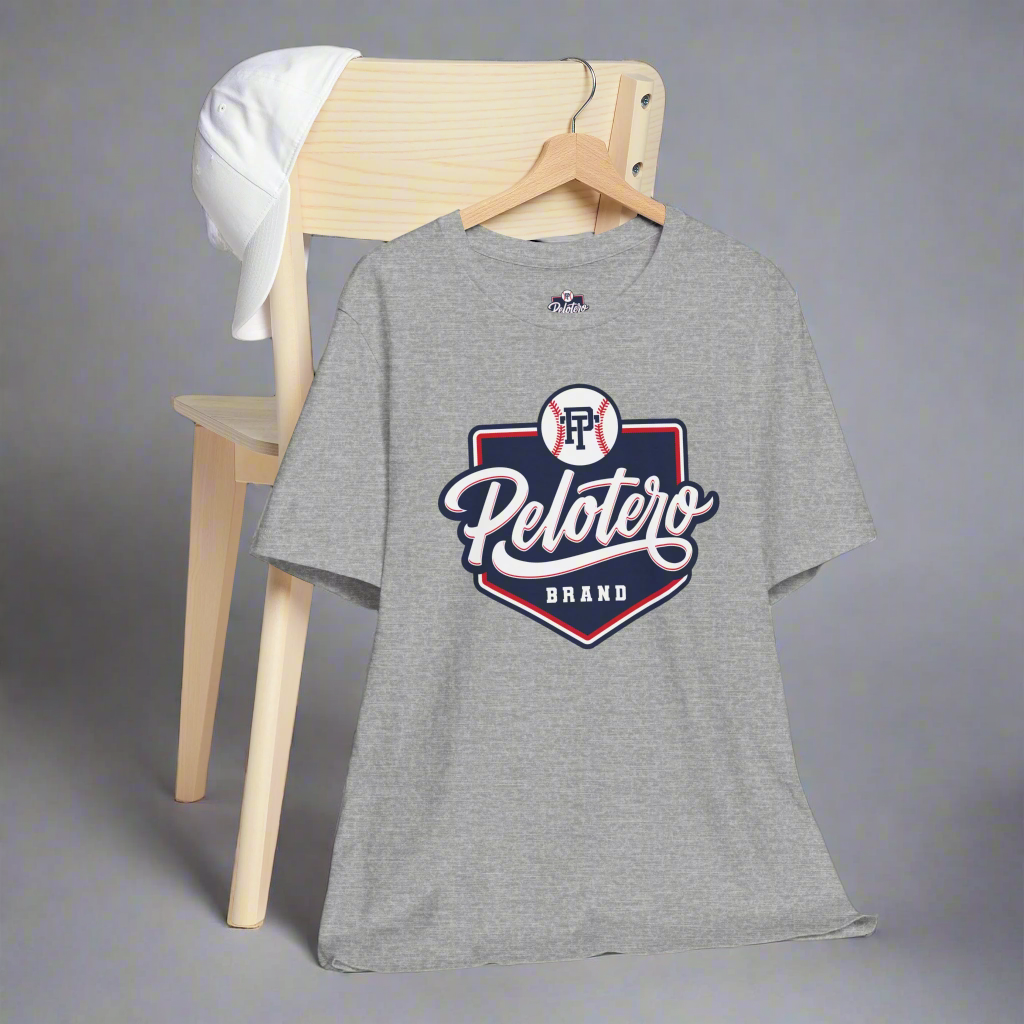 Gray t-shirt with 'Pelotero Brand' logo on a wooden chair against a gray background