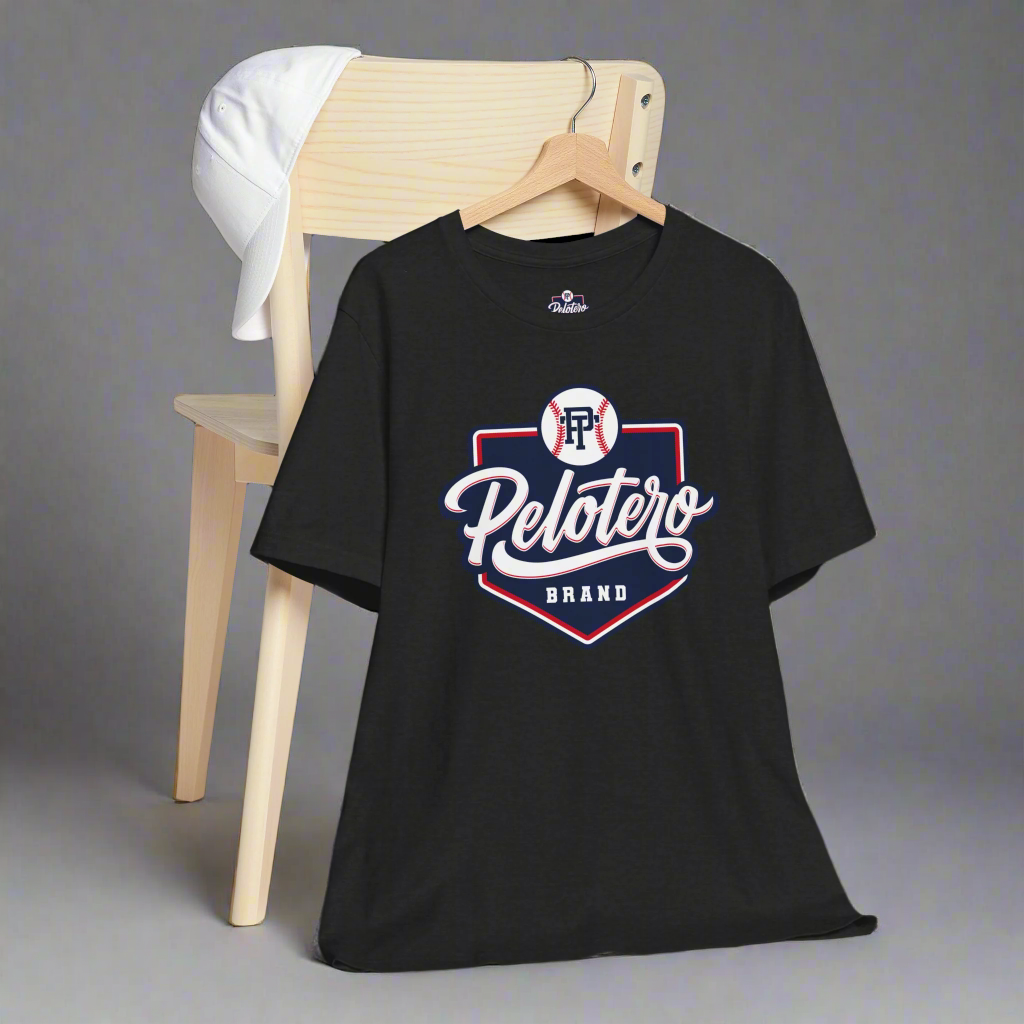 Black t-shirt with 'Pelotero Brand' logo on a wooden chair against a gray background