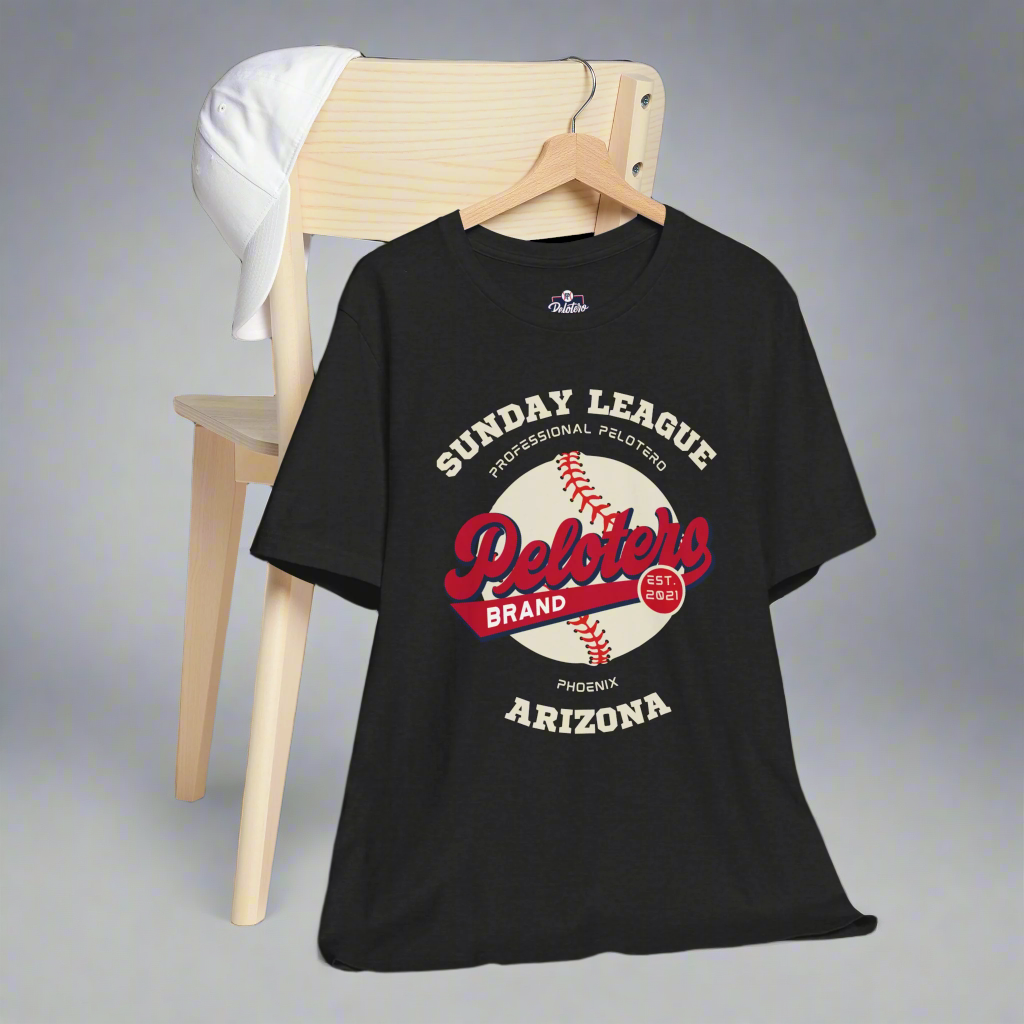 Black t-shirt with 'Sunday League' and 'Peloters Brand' graphics on a wooden chair.