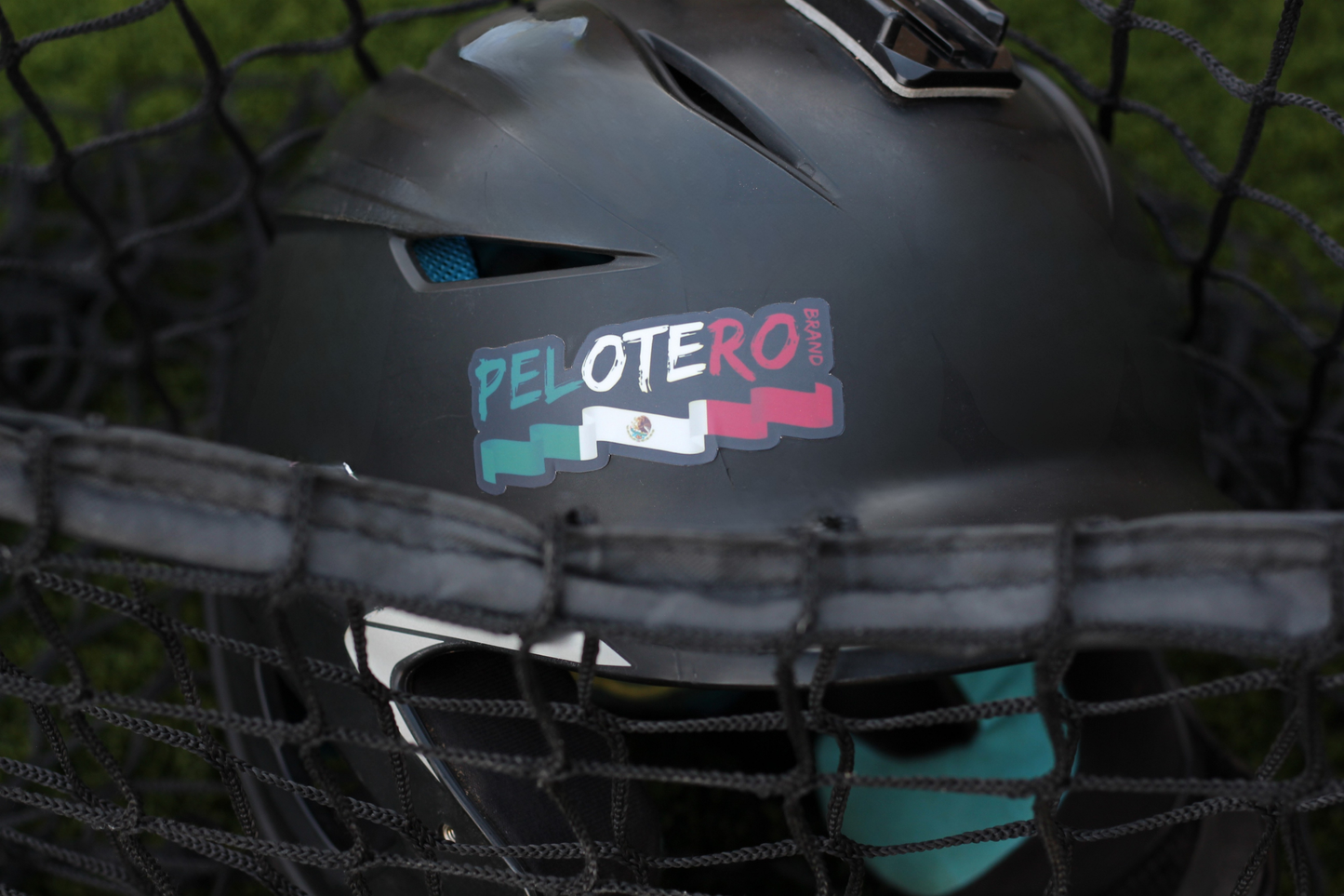 Black helmet with 'Pelotero' sticker in a netted background