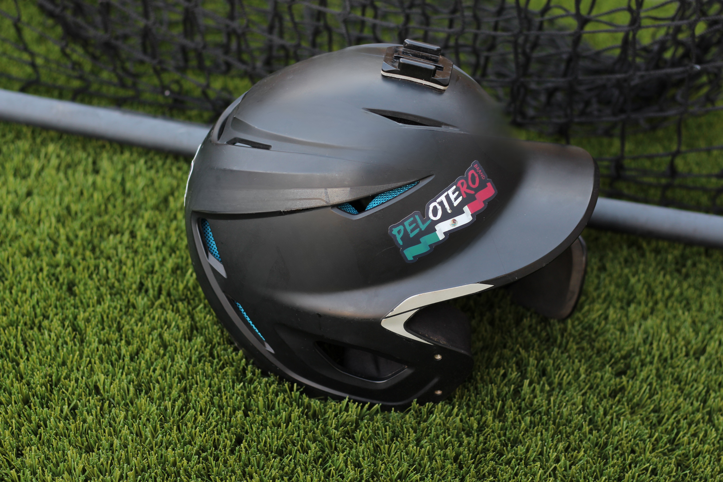 Black helmet with 'Pelotero' branding on grass