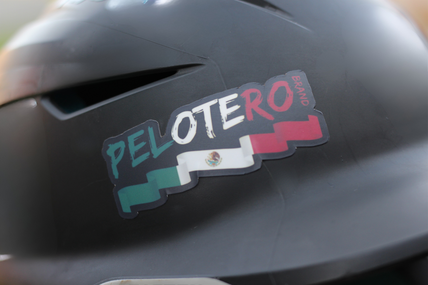 Helmet with a 'Pelotero' sticker on a dark background